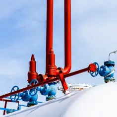 Zawory i rury przy białym zbiorniku na gaz. Zastanawiasz się, na ile wystarcza zbiornik na gaz 2700?