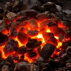 Żarzące się **paliwo stałe** w kuźni, gotowe do rozgrzania metalu.